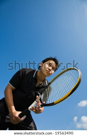 A young sporty asian tennis player receiving serve