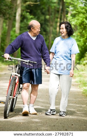 A senior active asian couple walking and exercise at the park