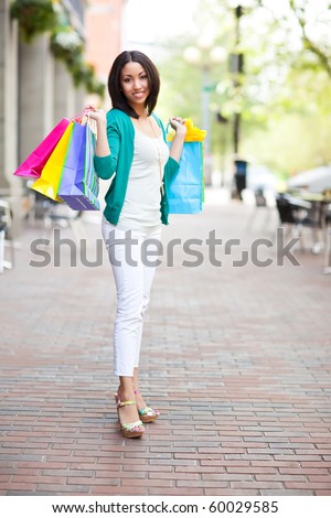 A shopping black woman carrying shopping bags outdoor