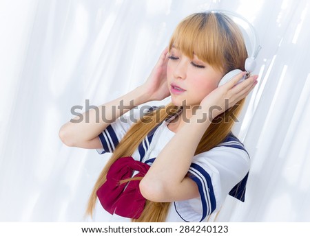 Asin girl in student sailor suit japanese style listen to music