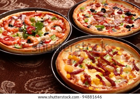 three pizza on table with pans