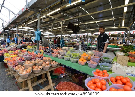 BIRMINGHAM, ENGLAND - JUNE 13: Unknown man trades a fruits in Bull Ring market on June 13, 2013 in Birmingham, England. Birmingham\'s outdoor Bull Ring market sees over six million shoppers every year