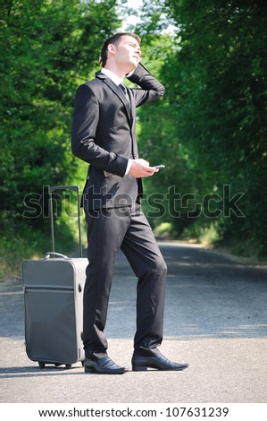 Business man with luggage on road