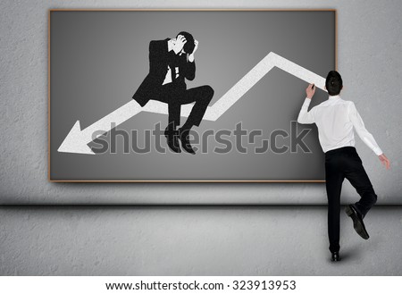 Young business man write down arrow on blackboard