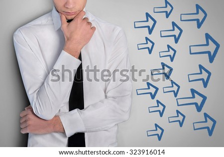 Young business man and arrows pointing right