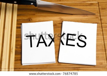Knife cut paper with taxes word