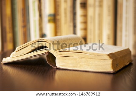 open book on the table and a bookshelf in the background
