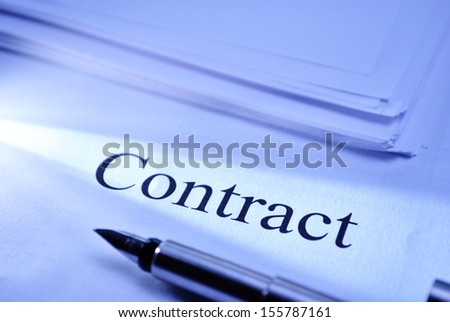Pen lying on a document headed Contract conceptual of a legal binding business contract or partnership