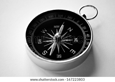 Close up view of a magnetic handheld compass with copyspace showing the needle, compass rose and cardinal points conceptual of planning, navigation, discovery, travel and strategy