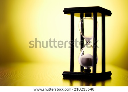Egg timer or hourglass on a graduated yellow background with copyspace in a conceptual image of passing time and time management