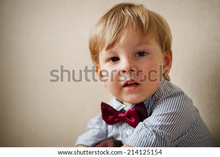 Portrait of Young Boy Wearing Bow Tie Against Plain Wall with Copyspace