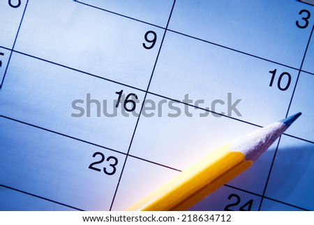 Pencil lying on a calendar with blank squares and dates conceptual of schedules, reminders and organization