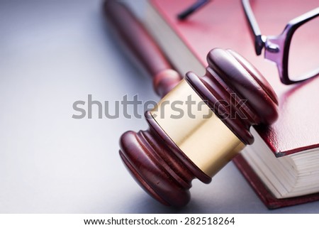 High Angle View of Cherry Wood Gavel with Brass Band Resting on Book Bound in Red Leather in Justice Concept Image with Copy Space