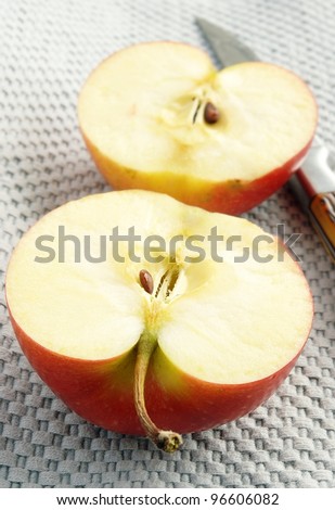 apple cut into two pieces and a knife on a napkin