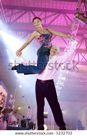 Fit adult dancing couple making rock-n-roll lift