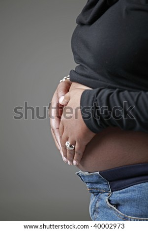 African American woman showing hands on stomach