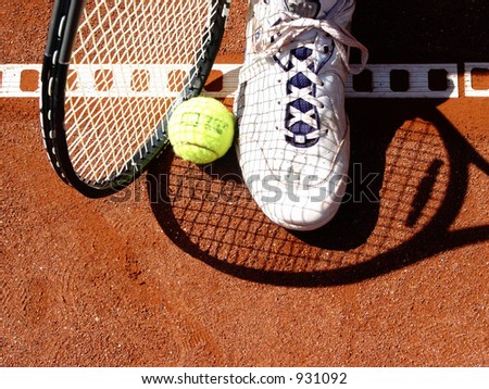 racket, ball and shoe on a tennis court