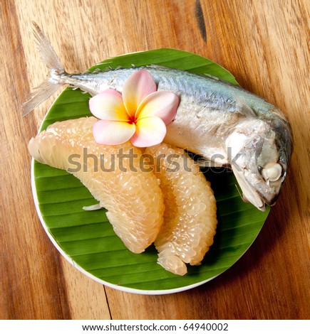 Grapefruit fried and tuna fish with flower on banana leaf.