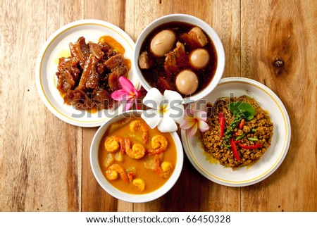 Thai Dinner set,shrimp curry,spicy pork basil,roast pork and pork stew with egg on wood background.