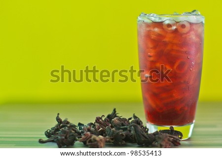 Herb drink Roselle juice on yellow background.