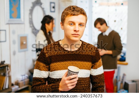 Portrait of handsome guy drinking coffee in home kitchen