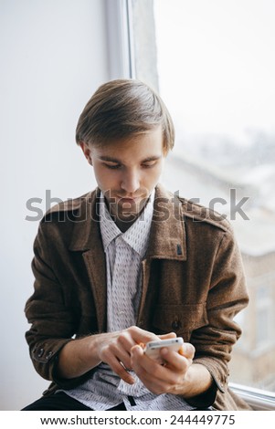 Young man dials number on mobile phone