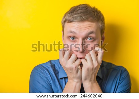 Blond young man. Gesture. does not know what to do, confusion. Isolated yellow background.