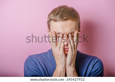 Young man in showing fatigue, sleepy, sleepy, closes his eyes with his hands. gesture. photo shoot.