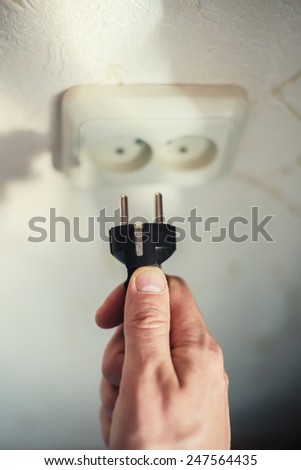 Plug in hand and socket. Close up