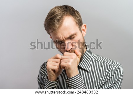 Full face portrait of man playing harmonica on gray background