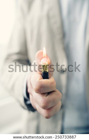 adult hand lighting a lighter and the warm flame