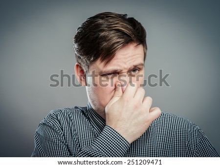 Man holding his nose against a bad smell