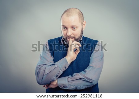 Closeup portrait young, puzzled business man thinking, deciding deeply something, finger on lips looking confused, unsure isolated grey wall background with texture. Emotion facial expression feeling