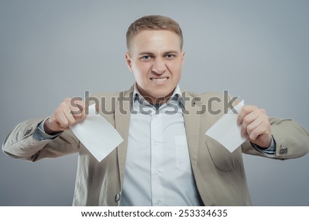 A picture of an angry businessman tearing documents