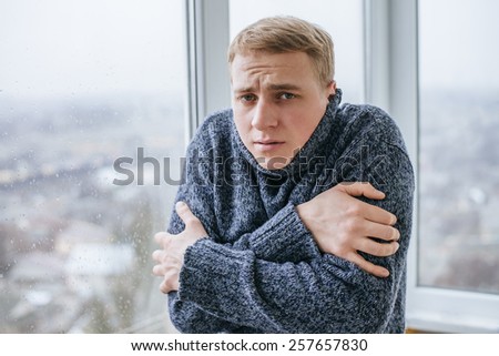 Young man feeling cold in flat near the window ストックフォト © 