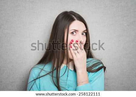A shocked and frightened woman covering her mouth in surprise and disbelief. Isolated