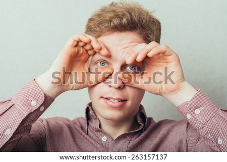 man making out of the hands glasses