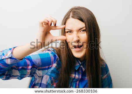 Girl showing small amount of something with fingers, isolated on white