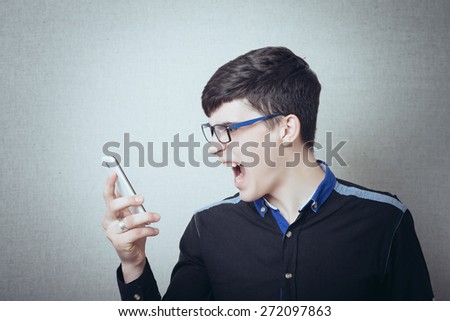 angry young man while answering smart phone not understood