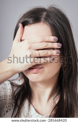 girl covering her eyes with her hand