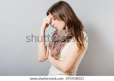 Young woman tired and wants to sleep on the hand. On a gray background.