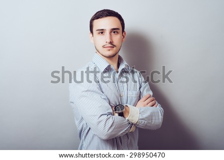 Serious young and attractive businessman  with his hands crossed on his chest