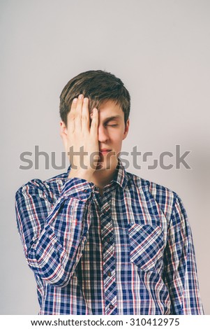 stress, headache, health care and people concept - unhappy man covering his eyes by hand over gray background