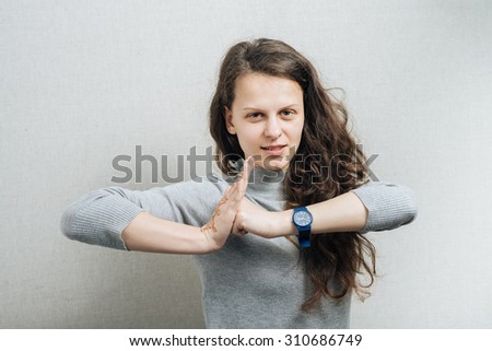 Woman showing revenge fist. On a gray background.