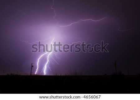 Bolts of lightning strike and splinter off during a monsoon rain storm in the Arizona desert.