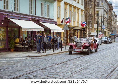PRAGUE, CZECH REPUBLIC - AUGUST 25, 2015: Sightseeing red retro car convertible. The architecture of the old town, Prague, Czech Republic