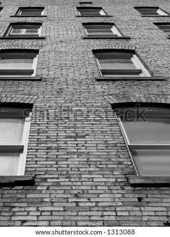 Windows in a brick wall on the side of an urban apartment building.