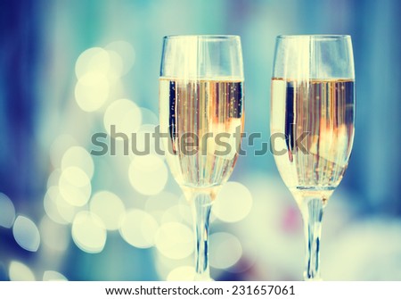 Two champagne glass on christmas bokeh background. Blue toned