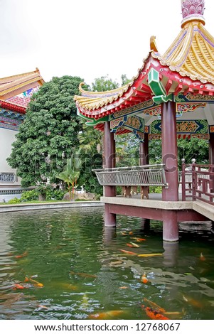 Traditional chinese temple pagoda over fish filled pond