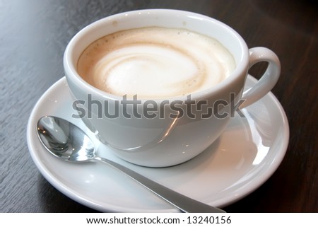 Coffee with foam swirl in round white mug
